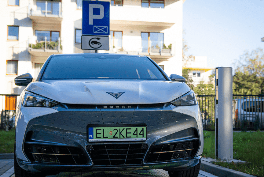 Samochód elektryczny ładowany na osiedlu mieszkaniowym